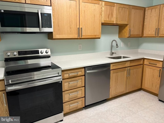 kitchen with light tile patterned flooring, stainless steel appliances, and sink