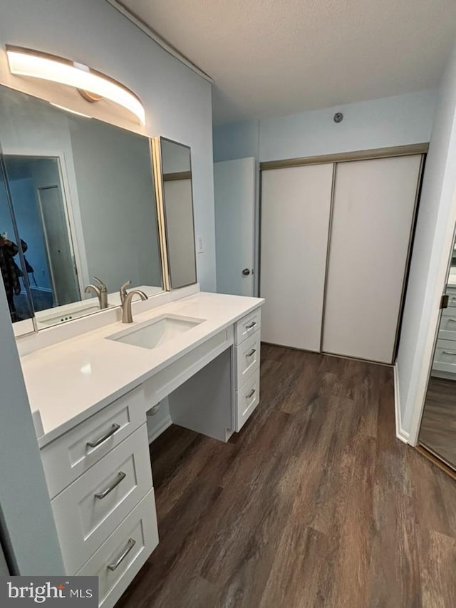 bathroom featuring vanity, wood-type flooring, and a textured ceiling