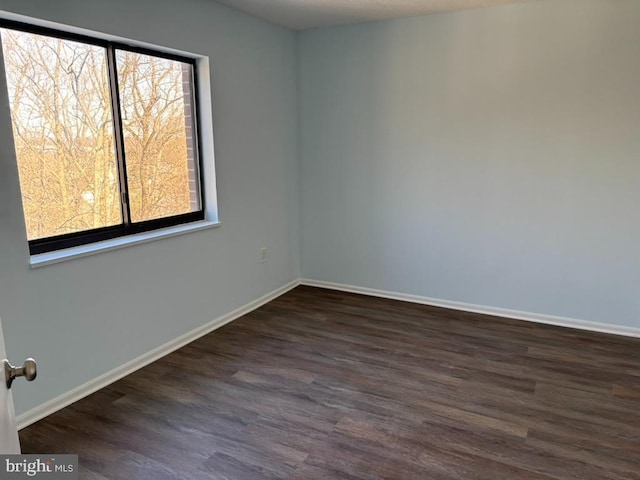 empty room with dark hardwood / wood-style flooring