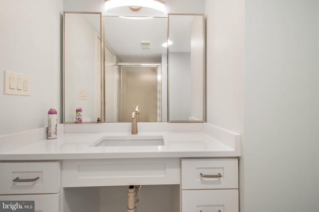 bathroom featuring walk in shower and vanity