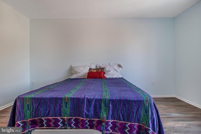 bedroom featuring hardwood / wood-style floors and a textured ceiling