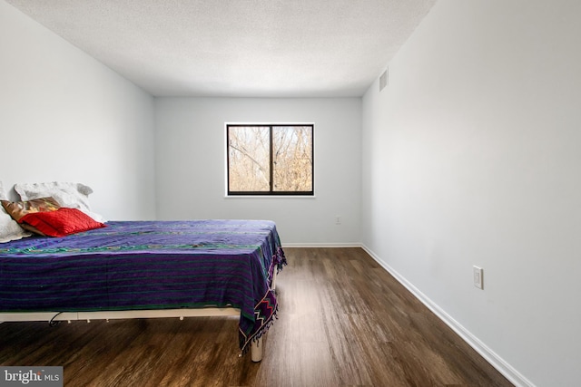 bedroom featuring wood-type flooring and a textured ceiling