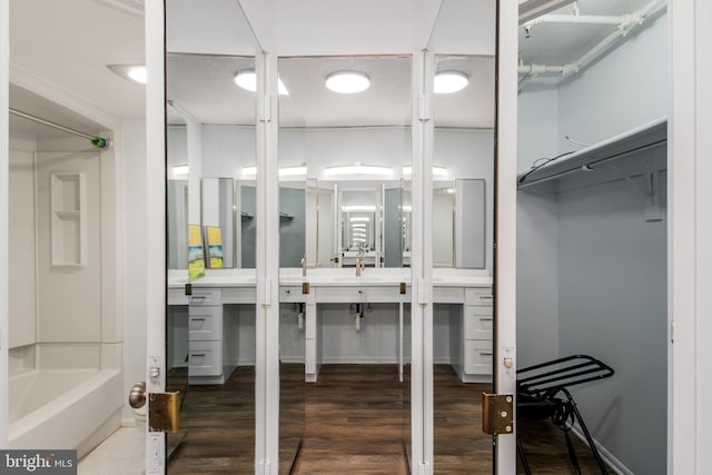 walk in closet with dark wood-type flooring