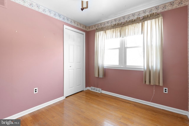 unfurnished bedroom with hardwood / wood-style floors, ceiling fan, and a closet