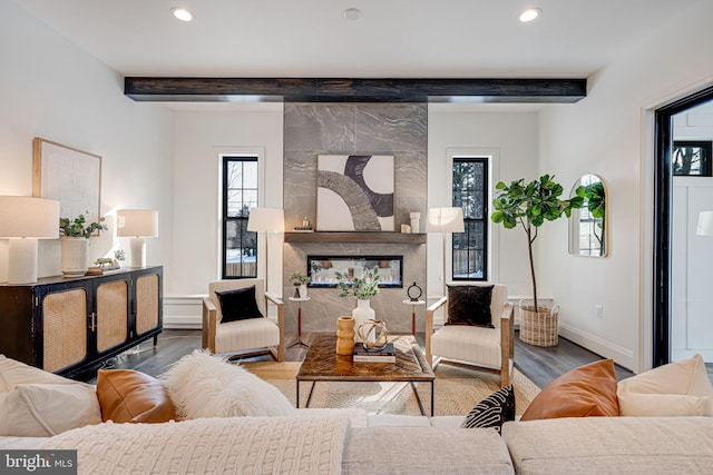 living room featuring beamed ceiling, a premium fireplace, and hardwood / wood-style flooring