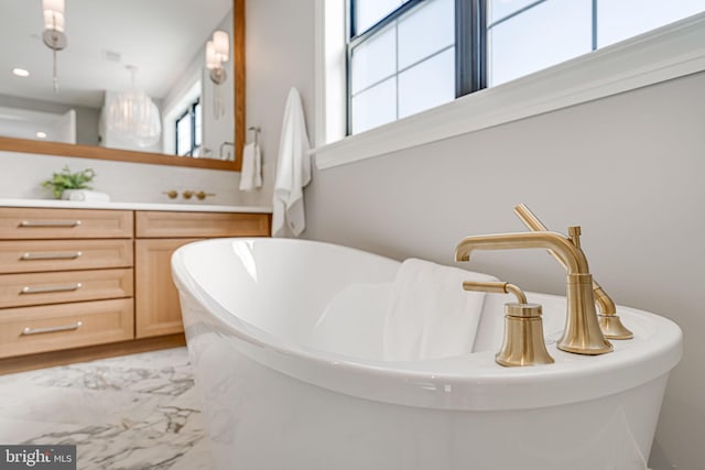 bathroom with vanity and a washtub