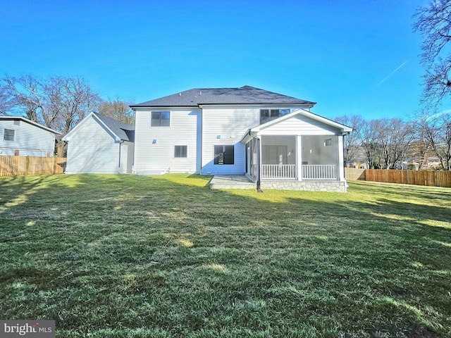 back of property with a yard and a sunroom