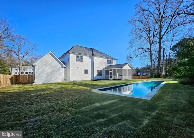 back of house with a fenced in pool, a yard, and an outdoor structure