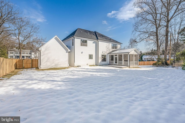 snow covered property with a sunroom