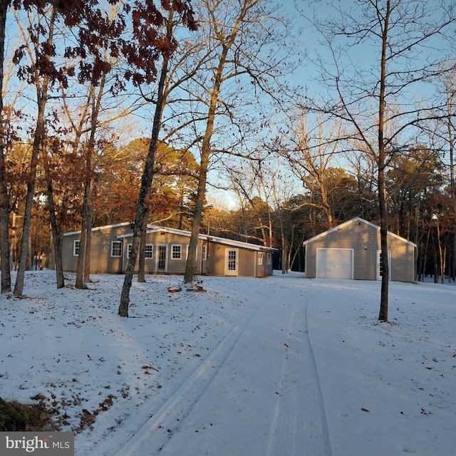 view of front of home featuring a garage and an outbuilding