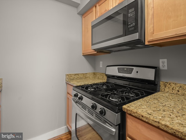 2615 4th St NE Unit 303, Washington, DC 20002 - kitchen with appliances with stainless steel finishes, baseboards, wood finished floors, light stone counters, and light brown cabinetry