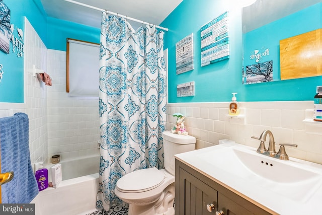 full bathroom featuring vanity, toilet, tile walls, and shower / bath combo