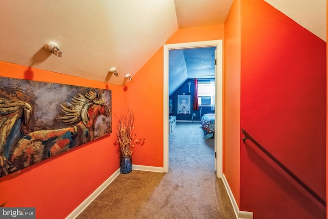 hall with lofted ceiling and carpet floors