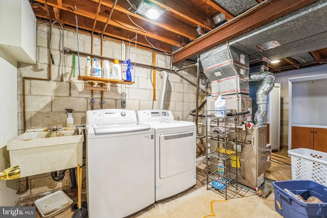 clothes washing area featuring washer and clothes dryer and sink