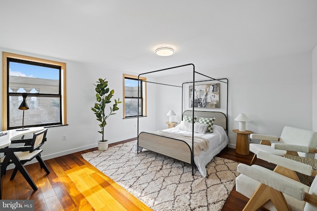 bedroom with multiple windows and hardwood / wood-style flooring