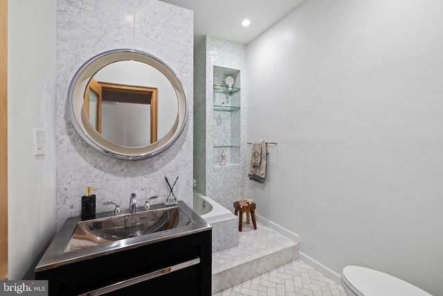 bathroom featuring vanity, backsplash, and toilet