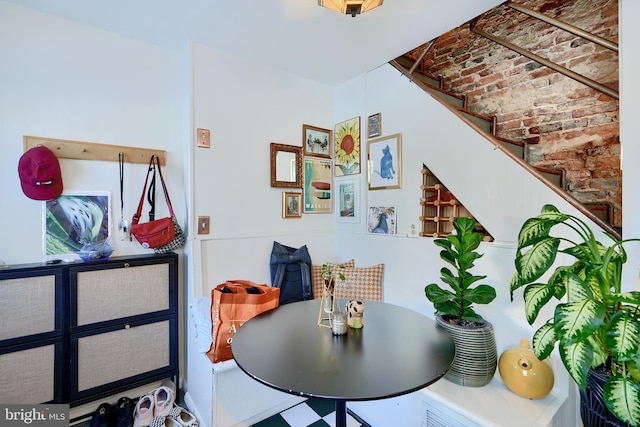 dining room featuring brick ceiling and brick wall