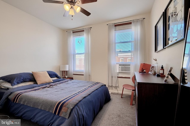 bedroom featuring ceiling fan, cooling unit, light colored carpet, and multiple windows