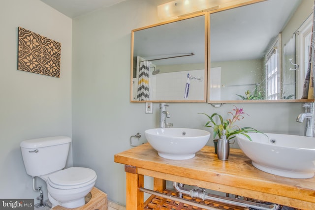 bathroom with toilet, walk in shower, and vanity