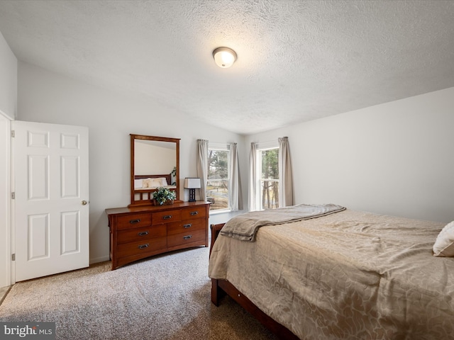 carpeted bedroom featuring lofted ceiling and a textured ceiling