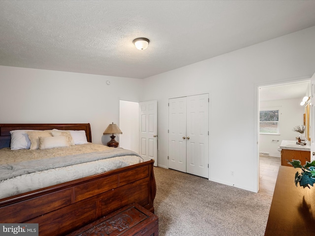 bedroom featuring light carpet, a textured ceiling, and a closet