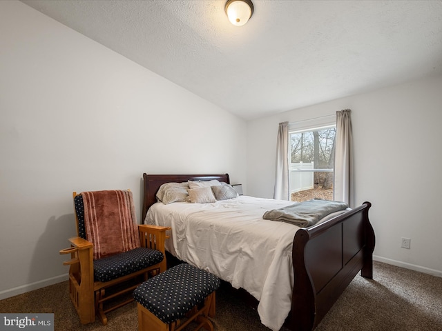 bedroom featuring dark carpet and a textured ceiling