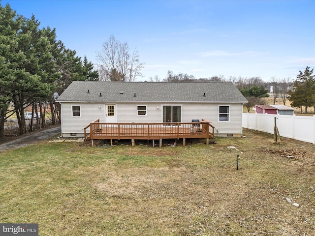 back of property with a wooden deck and a lawn