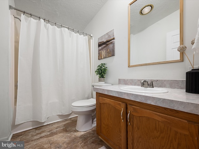 full bathroom with vanity, shower / tub combo, toilet, and a textured ceiling