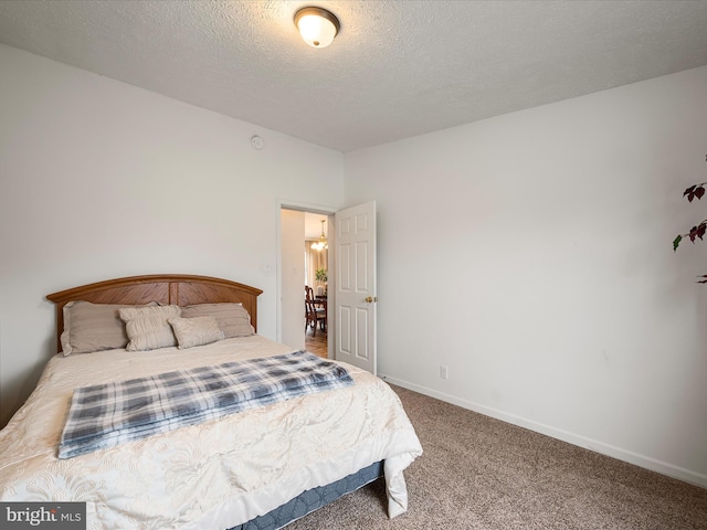 bedroom with a textured ceiling and carpet