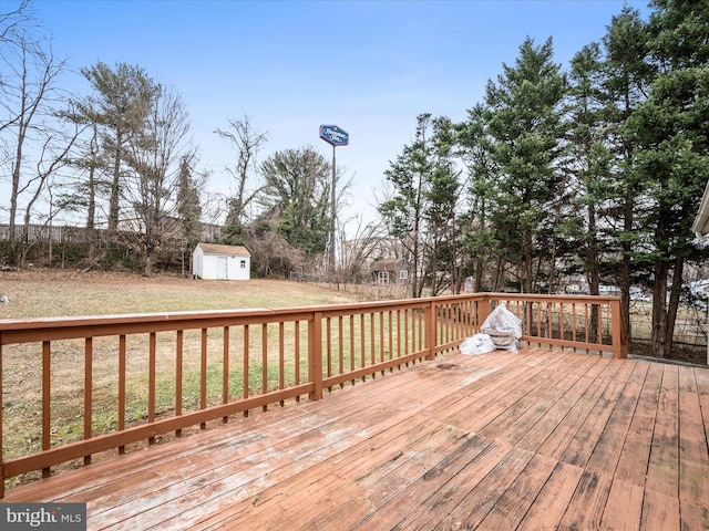 wooden terrace featuring a shed and a yard