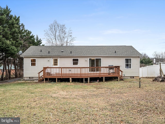 rear view of house featuring a wooden deck and a lawn