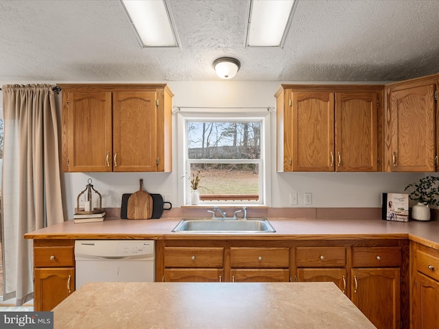 kitchen featuring white dishwasher, sink, and a textured ceiling