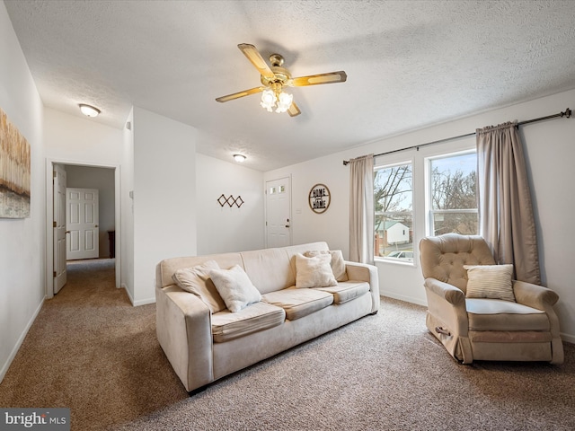 living room with ceiling fan, vaulted ceiling, carpet, and a textured ceiling