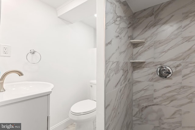 bathroom featuring vanity, toilet, and tiled shower