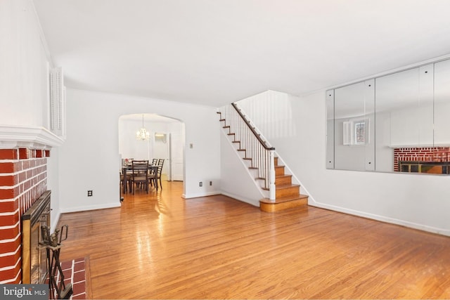 unfurnished living room with a brick fireplace and wood-type flooring