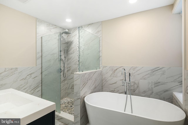 bathroom featuring vanity, tile walls, and separate shower and tub