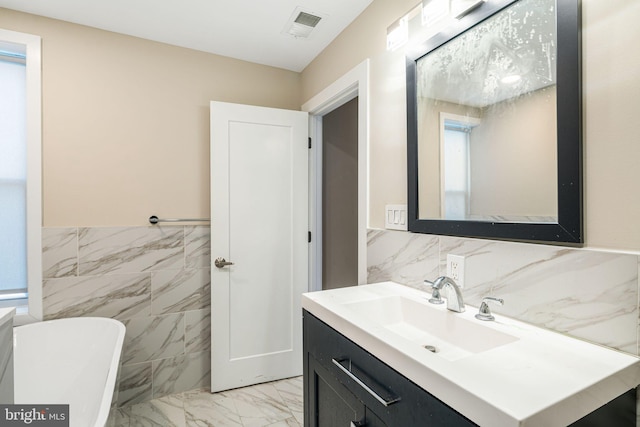 bathroom featuring vanity and tile walls