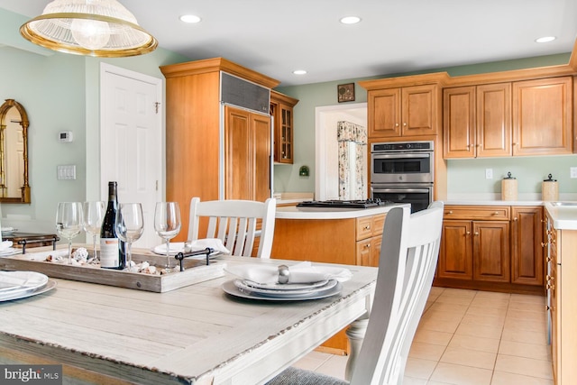 kitchen featuring hanging light fixtures, paneled fridge, light tile patterned floors, and double oven