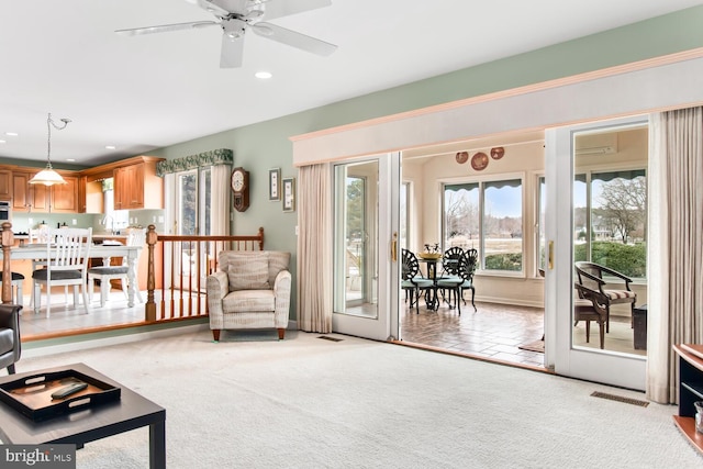 carpeted living room with sink and ceiling fan