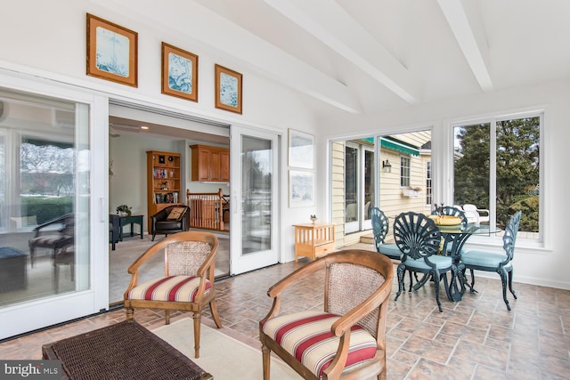 sunroom featuring lofted ceiling with beams and french doors