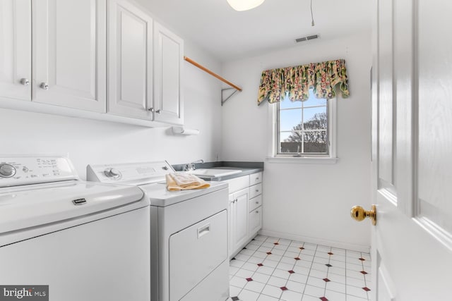 washroom with cabinets, sink, and washer and clothes dryer