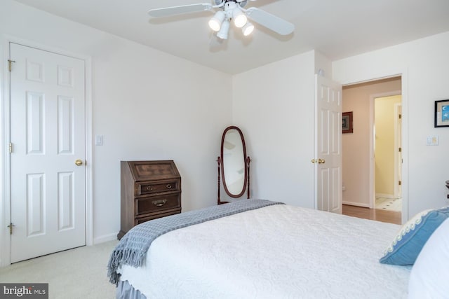 carpeted bedroom featuring ceiling fan and ensuite bath