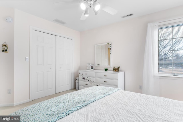 bedroom with light carpet, ceiling fan, and a closet