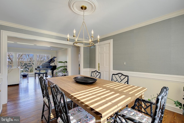 dining room featuring dark hardwood / wood-style flooring, a notable chandelier, and crown molding