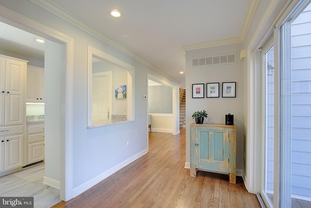 hall with crown molding and light wood-type flooring