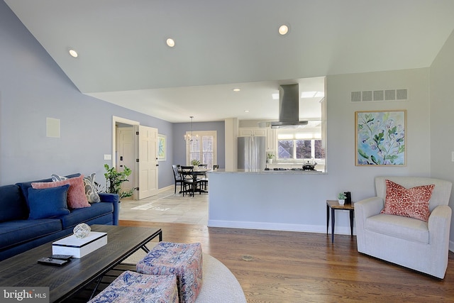 living room with a chandelier and light hardwood / wood-style flooring