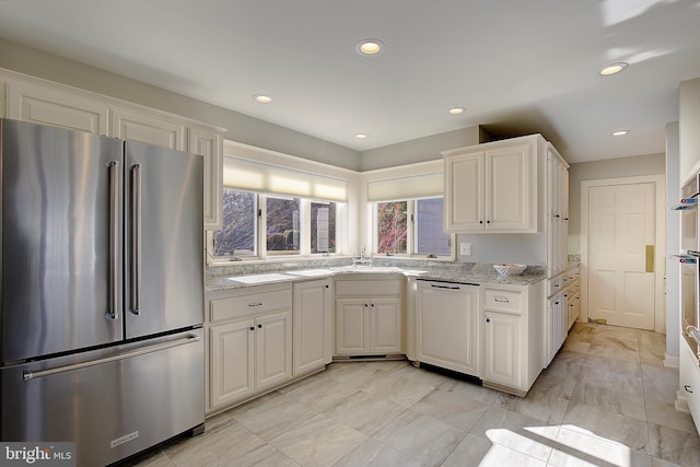 kitchen featuring dishwasher, white cabinetry, light stone countertops, and high end fridge