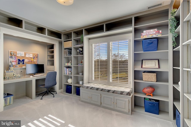 carpeted office featuring built in desk