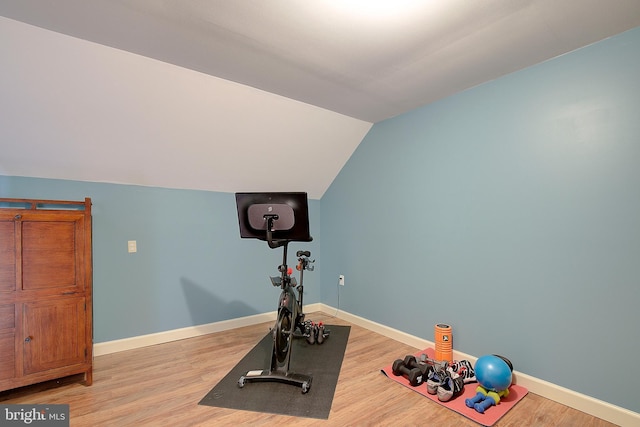 exercise area featuring lofted ceiling and hardwood / wood-style floors