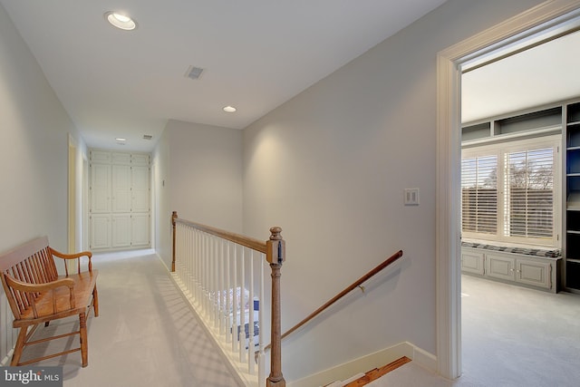 hallway featuring light colored carpet